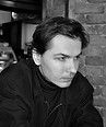 Black and white photo of a man looking pensively to the right.
