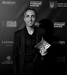 Smiling man holds geometric award at Міжнародний кінофестиваль Молодість, avalon sponsor.
