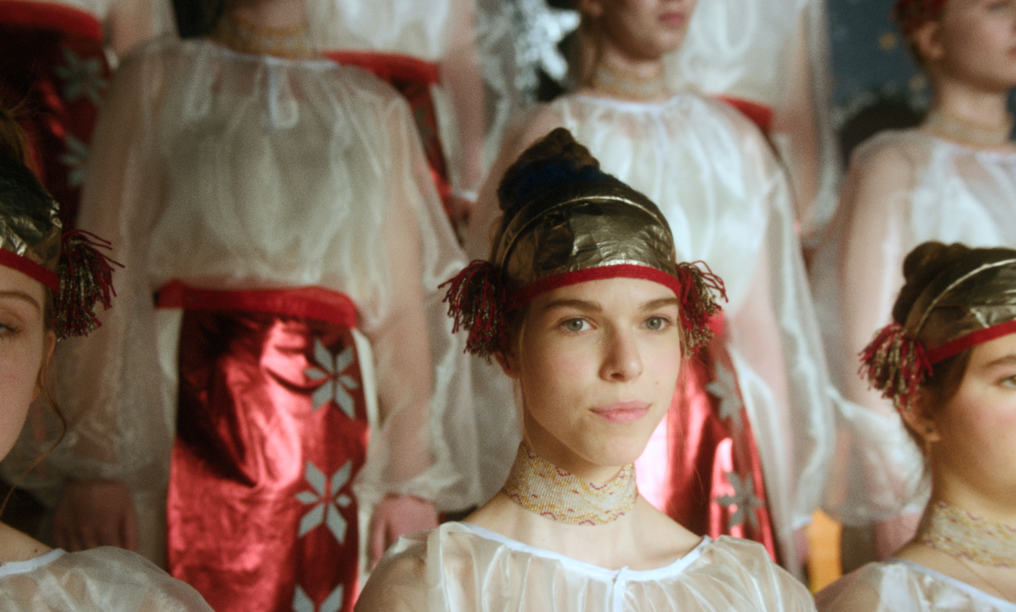 Close-up of a young performer in traditional costume among a folk ensemble — a still from Kira’s Dre