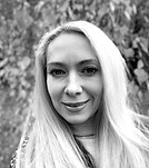 Black and white portrait of a smiling woman with long blonde hair.
